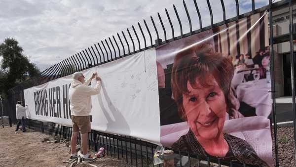 Jeff Robb, a Seattle resident wintering in Tucson, signs a banner supporting Nancy Guthrie in Tucson Ariz., on Friday, Feb. 13, 2026.