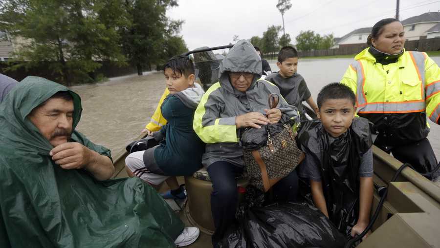 Evacuees ride in a boat down Tidwell Rd. as floodwaters from Tropical Storm Harvey rise Monday, Aug. 28, 2017, in Houston