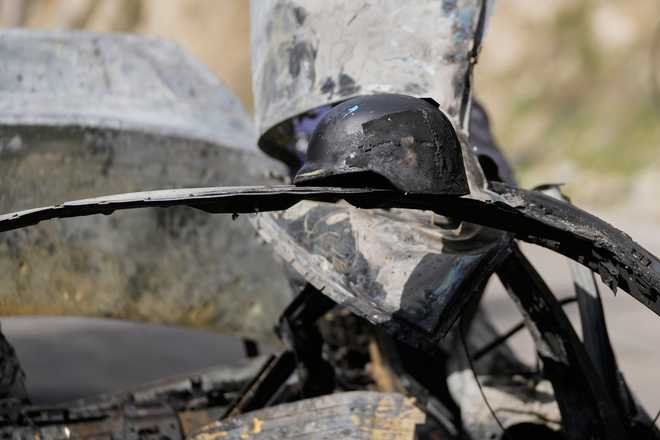 A burned press helmet rests on the charred car that was carrying Hezbollah's al-Manar TV correspondent Ali Shoeib, Beirut's based Al-Mayadeen TV reporter Fatima Ftouni and her brother, video journalist Mohammed Ftouni, before they were killed in an Israeli airstrike, in the town of Jezzine, south Lebanon, Saturday, March 28, 2026.