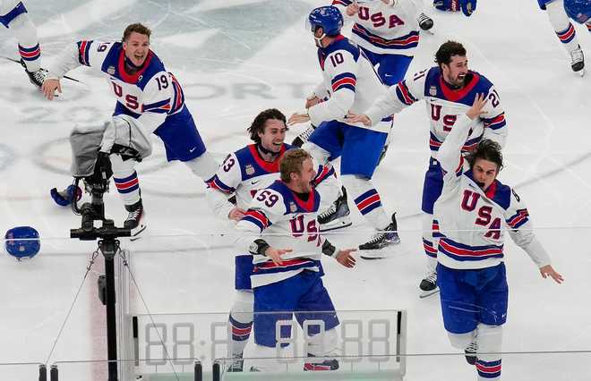 United States' Jack Hughes (86), right, celebrates with teammates after scoring the game winning goal against Canada in sudden death overtime during the men's ice hockey gold medal game at the 2026 Winter Olympics, in Milan, Italy, Sunday, Feb. 22, 2026.
