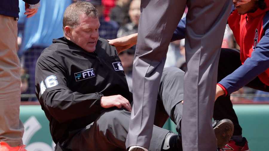 Home plate umpire Ron Kulpa is tended to after being hit with a foul ball during the fourth inning of a baseball game between the Boston Red Sox and the Chicago White Sox at Fenway Park, Sunday, May 8, 2022, in Boston.