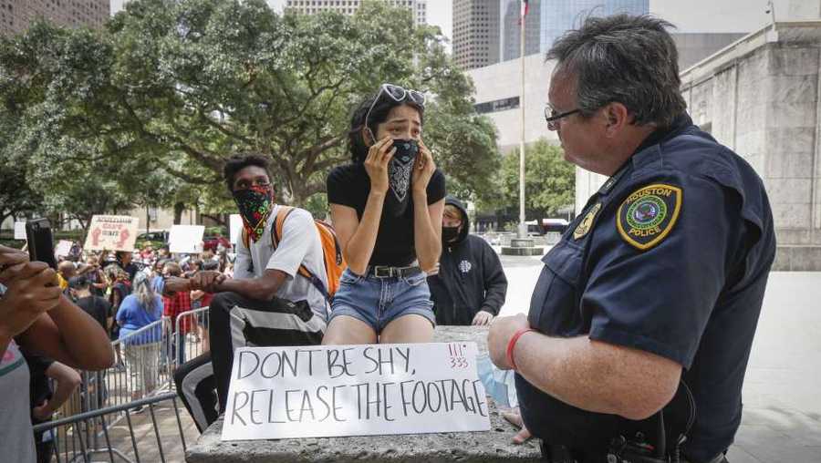 Aaliyah Pozo talks to Houston Police Commander Wyatt Martin during a rally to eliminate police misconduct Wednesday, June 10, 2020, in Houston.