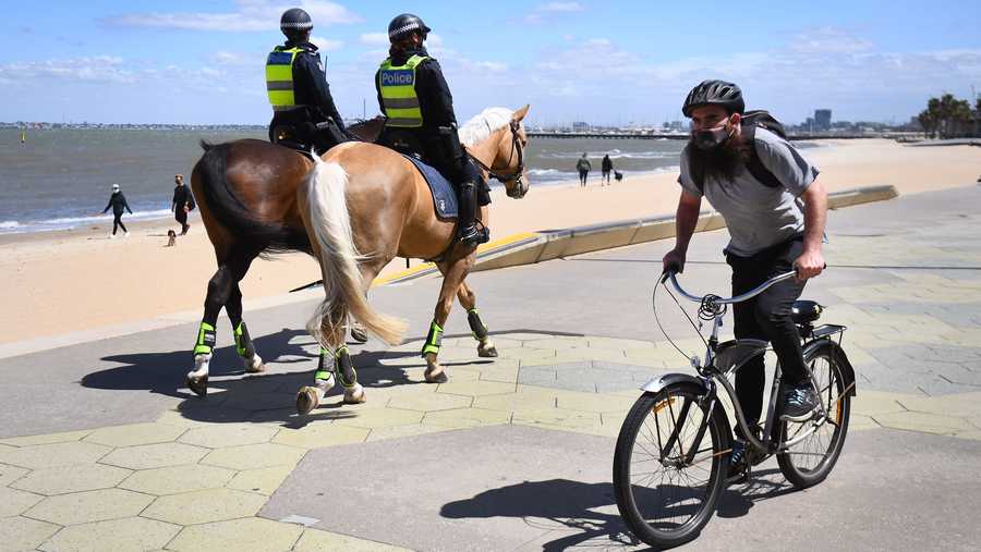 Police patrol on horseback along the St Kilda Esplanade in Melbourne on Oct. 26, 2020. The city was previously at the epicenter of Australia's coronavirus outbreak.