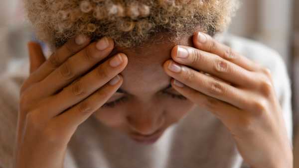 Woman with headache rubbing forehead