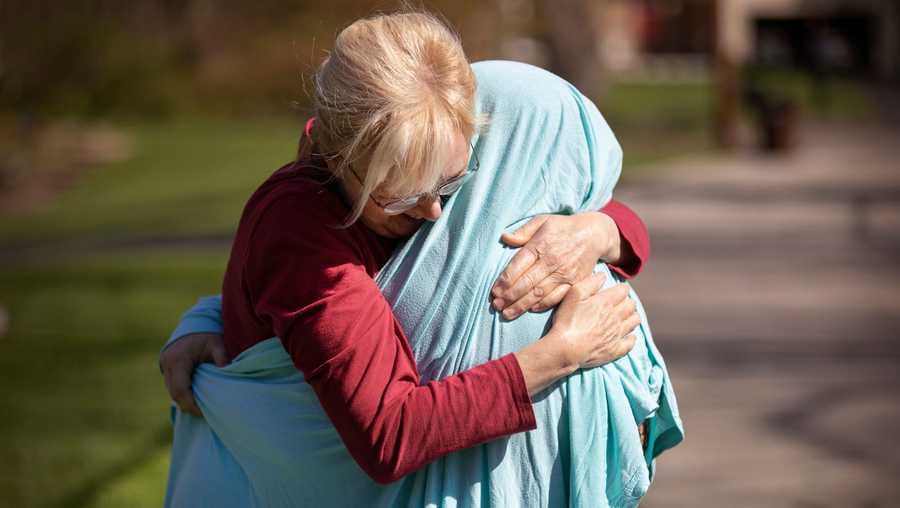 Cheryl Norton, of Blue Ash, hugs her daughter, Kelsey Kerr, 28, an ICU nurse at Christ Hospital and working the front lines during the new coronavirus pandemic, Friday, April 3, 2020.