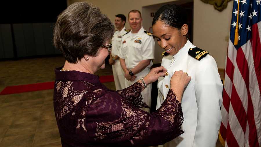 Lt. j.g. Madeline Swegle receives her naval aviator Wings of Gold from her friend Barbara Dodson during a ceremony aboard Naval Air Station Kingsville.