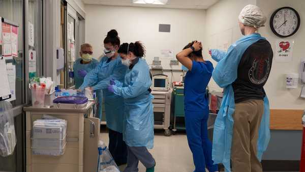 Healthcare workers put on PPE on the Covid-19 ICU floor of the University of Massachusetts (UMass) Memorial Hospital in Worcester, Massachusetts, U.S., on Monday, Dec. 27, 2021. On Friday, the Massachusetts Department of Public Health reported 10,040 new confirmed Covid cases, marking the third consecutive day that a record was set for most cases in a single day in the state. Photographer: Allison Dinner/Bloomberg via Getty Images