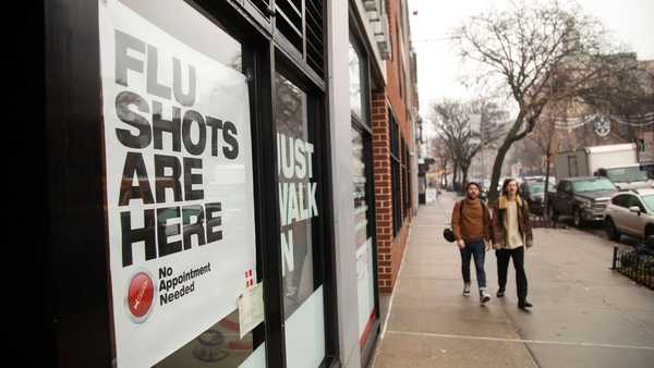 People walk past an urgent care facility offering flu shots in New York on Dec. 7, 2022.