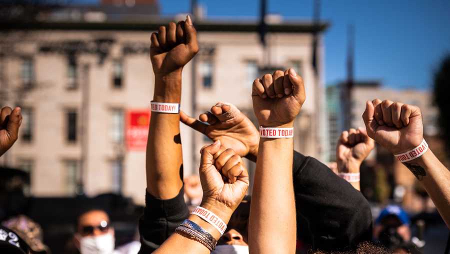 Black Lives Matter protesters display their "I VOTED" wristbands after leaving the polling place at the KFC YUM! Center on Oct. 13, 2020 in Louisville, Kentucky.