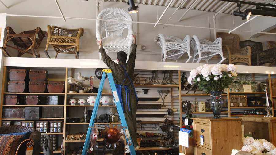 Sales associate Chris Reese balances a wicker rocker as he places it atop a high shelf inside a Pier 1 Imports store March 4, 2002 in Arlington Heights, IL.