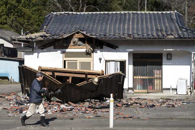 Sushi maker Akio Hanzawa walks in front of his damaged restaurant in Shiroishi, Miyagi prefecture on March 17, 2022, after a 7.3-magnitude earthquake rocked east Japan the night before.