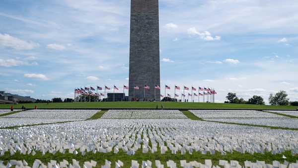 WASHINGTON, DC - SEPTEMBER 20: The Washington monument sits as a backdrop to the 'In America: Remember' public art installation near on the National Mall on Monday, Sept. 20, 2021 in Washington, DC. The installation commemorates all the Americans who have died due to COVID-19, a concept by artist Suzanne Brennan Firstenberg, includes more than 650,000 small plastic flags, some with personal messages to those who have died, planted in 20 acres of the National Mall.  (Kent Nishimura / Los Angeles Times via Getty Images)