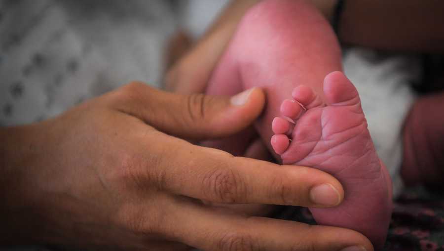 A mother holds the foot of her newborn baby on July 7, 2018 at the hospital in Nantes, western France.