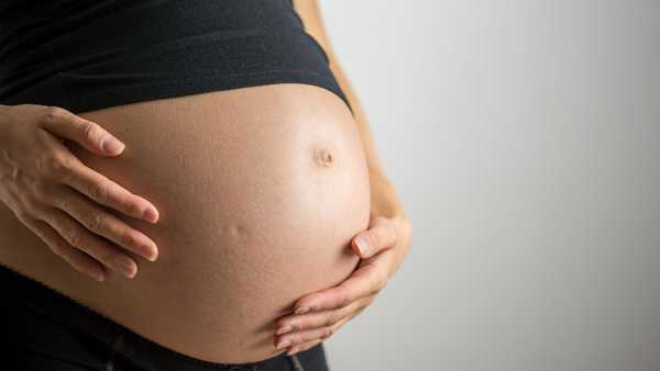 Closeup of pregnant belly in ninth month of pregnancy.