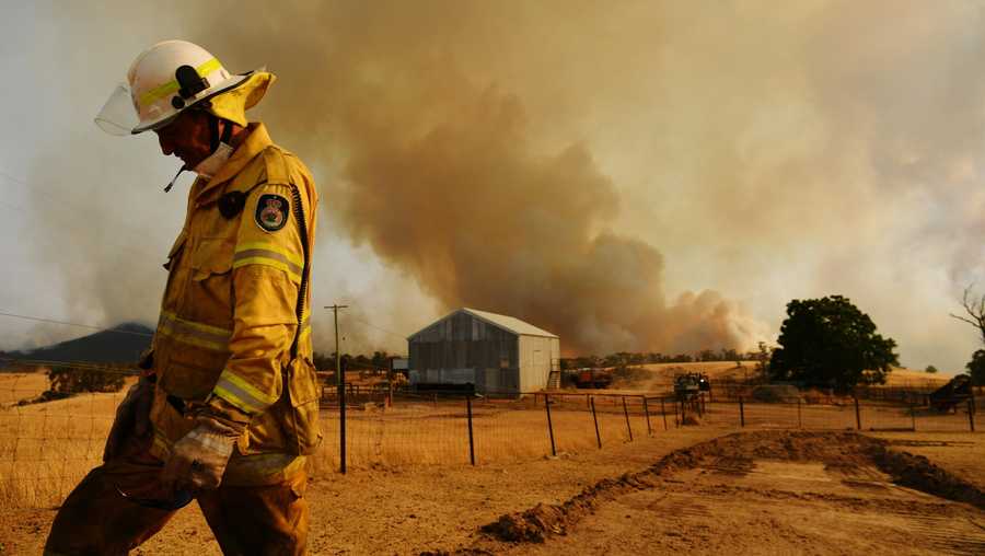 All fires burning in the Australian state of New South Wales have been declared contained for the first time this season. A Rural Fire Service firefighter Trevor Stewart views a flank of a fire on Jan. 11 in Tumburumba, New South Wales.