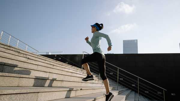 Fitness sports woman running up stairs in city