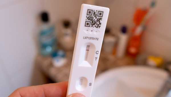 A detail of a hand holding a lateral flow test that shows a negative result in a domestic bathroom on 'Freedom Day', 19th July 2021, in London, England. 'Freedom Day' is the date that Prime Minister Boris Johnson's UK government set as the end of Covid pandemic social distancing conditions with the end of mandatory face coverings in shops and public transport.