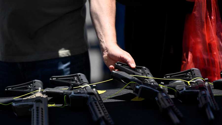 A customer examines a Valor Industries LLC California-compliant AR-15 style rifle displayed for sale at a vendor booth at the Crossroads of the West Gun Show at the Orange County Fairgrounds on June 5, 2021 in Costa Mesa, California.