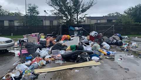 trash on the ground outside a metrowide apartments property