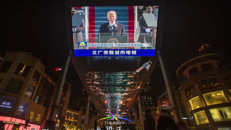 A large video screen shows a government news report about the inauguration of President Joe Biden at a shopping mall in Beijing, Thursday, Jan. 21, 2021.
