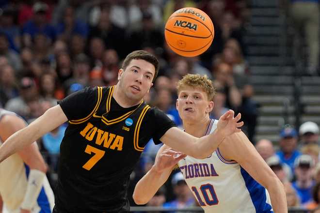 Iowa forward Alvaro Folgueiras (7) and Florida forward Thomas Haugh (10) go after a loose ball during the first half in the second round of the NCAA college basketball tournament, Sunday, March 22, 2026, in Tampa, Fla.