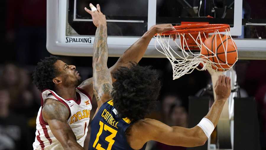 Iowa State guard Izaiah Brockington dunks the ball over West Virginia forward Isaiah Cottrell (13) during the second half of an NCAA college basketball game, Wednesday, Feb. 23, 2022, in Ames, Iowa. (AP Photo/Charlie Neibergall)