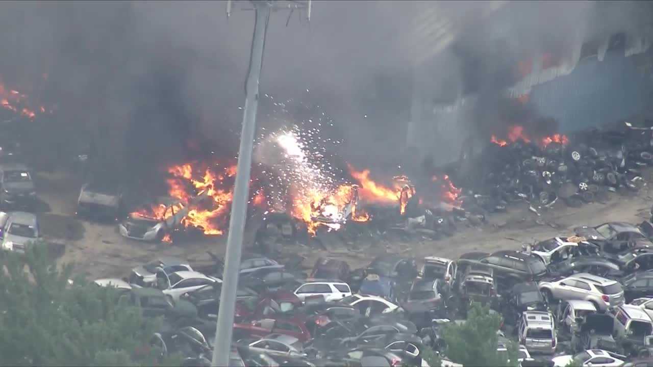 Junkyard fire sends thick plume of black smoke into sky