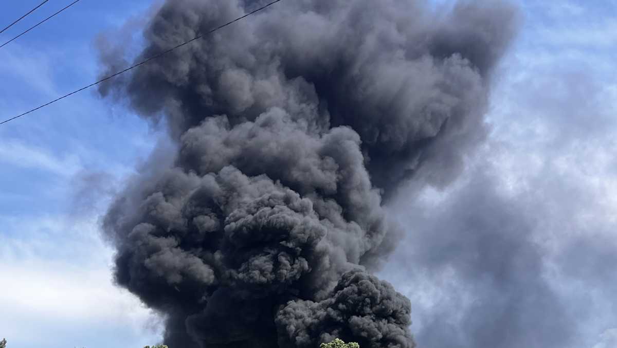 Tires and building burn, creating big black plumes of smoke seen across ...