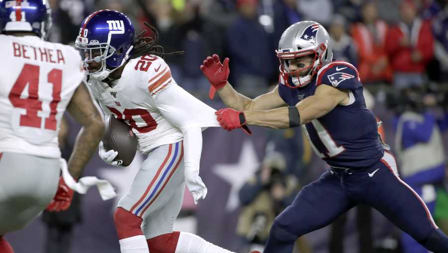 New York Giants cornerback Janoris Jenkins, left, runs with the ball after intercepting a pass intended for New England Patriots wide receiver Julian Edelman, right, in the first half of an NFL football game, Thursday, Oct. 10, 2019, in Foxborough, Mass. (AP Photo/Elise Amendola)