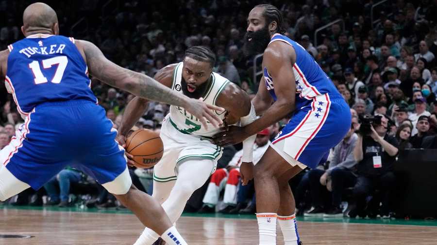 Boston Celtics guard Jaylen Brown (7) drives to the basket between Philadelphia 76ers guard James Harden, right, and forward P.J. Tucker (17) during the first half of an NBA basketball game, Wednesday, Feb. 8, 2023, in Boston.