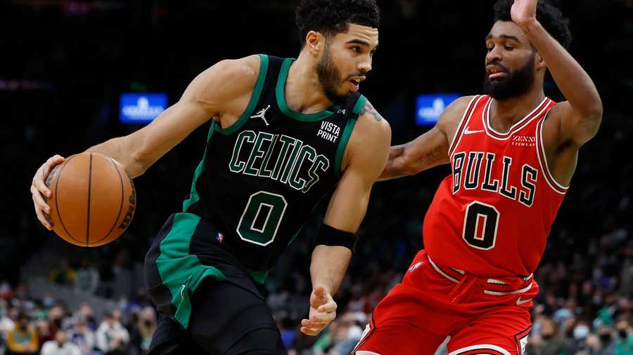 Boston Celtics' Jayson Tatum, left, drives past Chicago Bulls' Coby White during the second half of an NBA basketball game, Saturday, Jan. 15, 2022, in Boston. (AP Photo/Michael Dwyer)