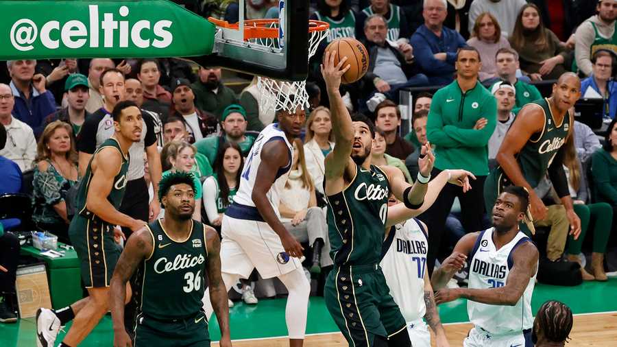 Boston Celtics forward Jayson Tatum (0) drives to the basket past Dallas Mavericks defenders during the first half of an NBA basketball game, Wednesday, Nov. 23, 2022, in Boston.