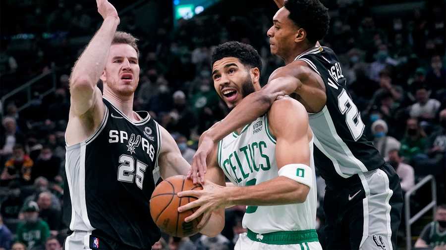 Boston Celtics forward Jayson Tatum, center, drives to the basket between San Antonio Spurs guard Devin Vassell, right, and center Jakob Poeltl (25) during the first half of an NBA basketball game, Wednesday, Jan. 5, 2022, in Boston. (AP Photo)