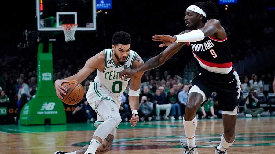 Boston Celtics forward Jayson Tatum (0) drives to the basket against Portland Trail Blazers forward Jerami Grant (9) during the first half of an NBA basketball game, Wednesday, March 8, 2023, in Boston.