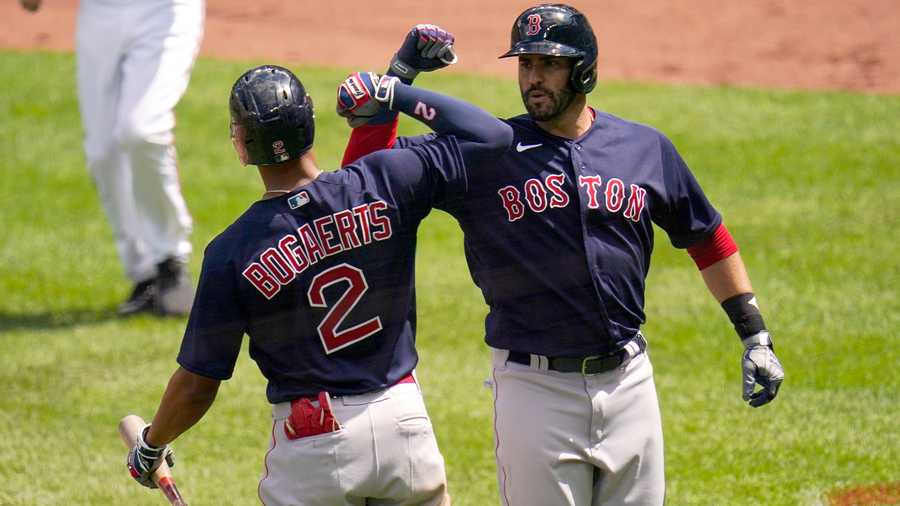 Boston Red Sox's J.D. Martinez, right, is greeted near home plate by Xander Bogaerts after hitting a solo home run off Baltimore Orioles starting pitcher Jorge Lopez during the third inning of a baseball game, Sunday, April 11, 2021, in Baltimore. (AP Photo)