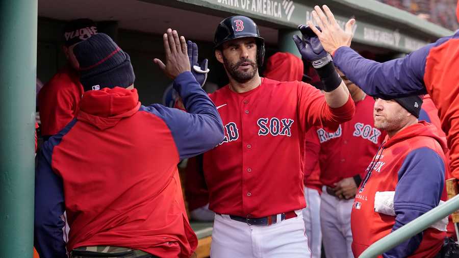 Boston Red Sox's J.D. Martinez, center, celebrates with teammates in the dugout after hitting a home run against the Tampa Bay Rays during the fourth inning of a baseball game Wednesday, Oct. 5, 2022, in Boston.