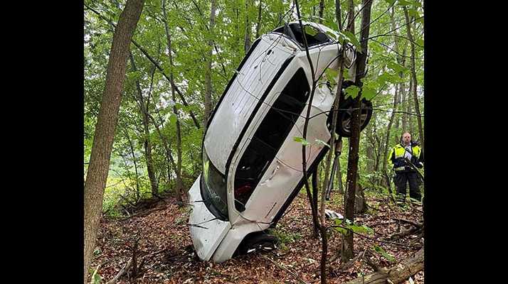 SUV found standing on nose wedged between trees along I-495
