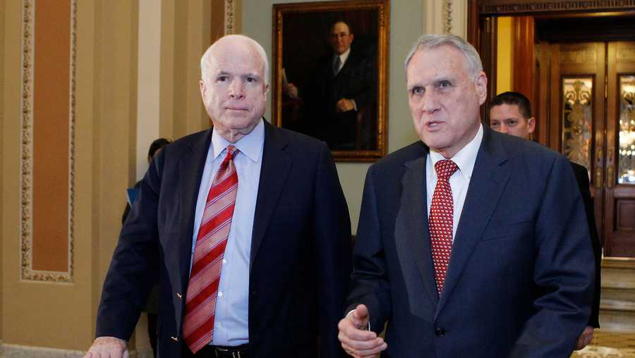 Senators John McCain (L) and Jon Kyl leave the Senate chamber to caucus in the US Capitol on December 30, 2012 in Washington, DC.