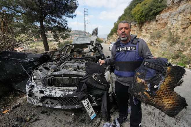 A journalist carries burned safety gear, following an Israeli airstrike on a car that killed Hezbollah's al-Manar TV correspondent Ali Shoeib, Beirut's based Al-Mayadeen TV reporter Fatima Ftouni and her brother, video journalist Mohammed Ftouni, in the town of Jezzine, south Lebanon, Saturday, March 28, 2026.