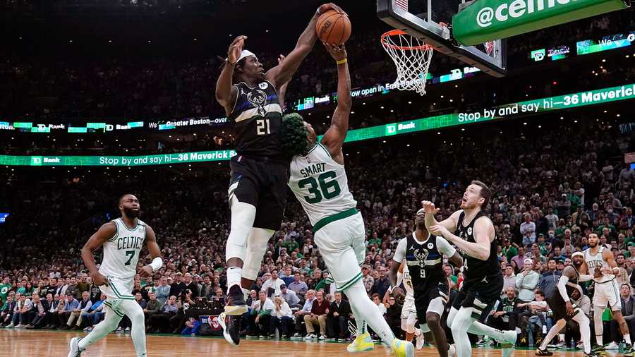 Milwaukee Bucks guard Jrue Holiday (21) blocks a shot by Boston Celtics guard Marcus Smart (36) in the final seconds of play during the second half of Game 5 of an Eastern Conference semifinal in the NBA basketball playoffs, Wednesday, May 11, 2022, in Boston. The Bucks won 110-107.