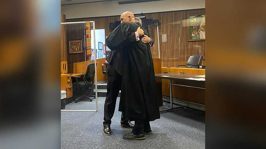 Edward Martell and Judge Bruce Morrow hugging after Martell is sworn in.