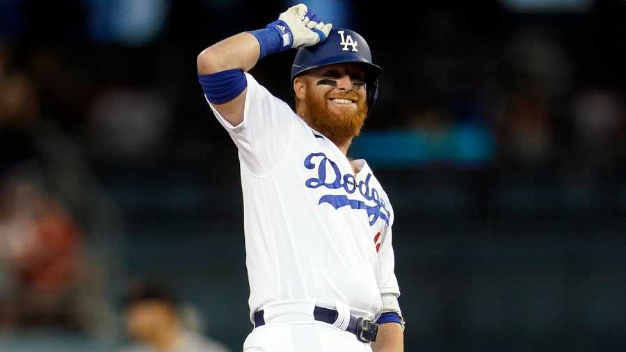 Los Angeles Dodgers' Justin Turner taps his helmet as he stands on second base after driving in two runs with a double during the third inning of a baseball game against the San Francisco Giants Thursday, July 21, 2022, in Los Angeles.