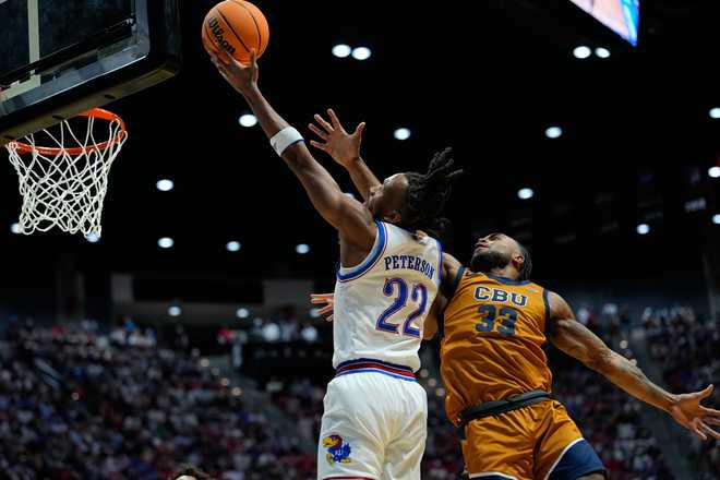 Kansas guard Darryn Peterson (22) shoots as California Baptist guard Martel Williams defends during the first half in the first round of the NCAA college basketball tournament Friday, March 20, 2026, in San Diego.