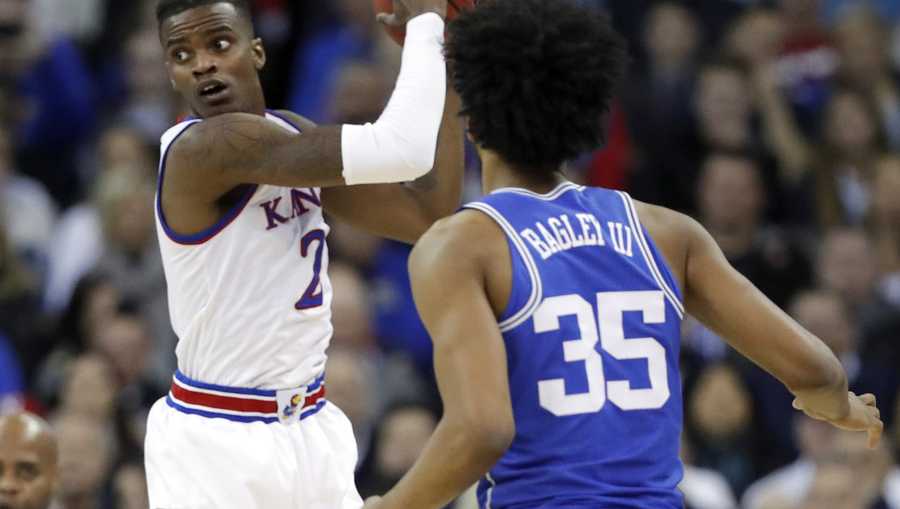 Kansas' Lagerald Vick, left, looks to pass as Duke's Marvin Bagley III watches during the first half of a regional final game in the NCAA men's college basketball tournament Sunday, March 25, 2018, in Omaha, Neb.