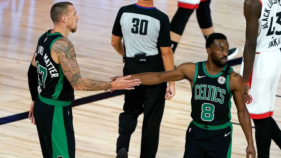 Boston Celtics' Daniel Theis (27) and Kemba Walker (8) slap hands after a play against the Toronto Raptors during the first half of an NBA basketball conference semifinal playoff game Sunday, Aug. 30, 2020, in Lake Buena Vista, Fla. (AP Photo/Ashley Landis)