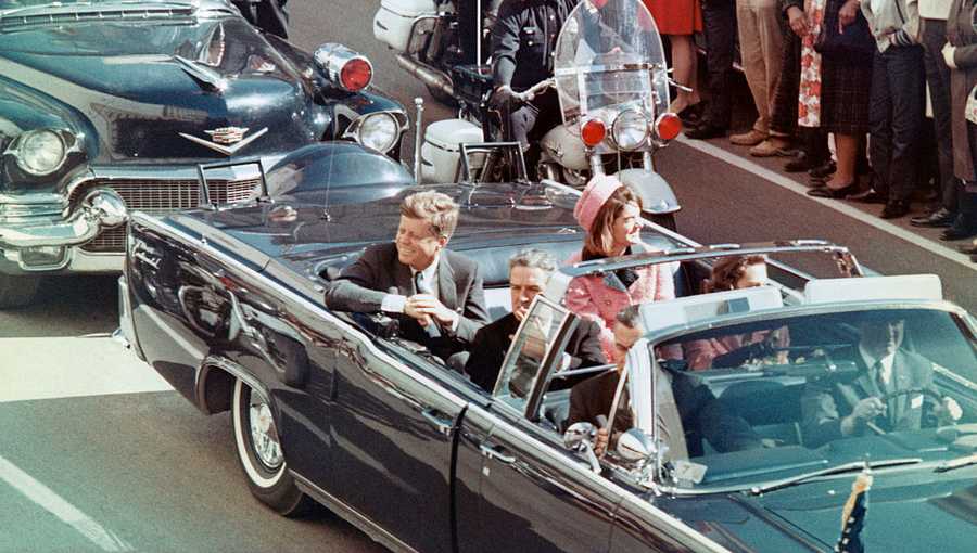 President and Mrs. John F. Kennedy smile at the crowds lining their motorcade route in Dallas, Texas, on November 22, 1963.