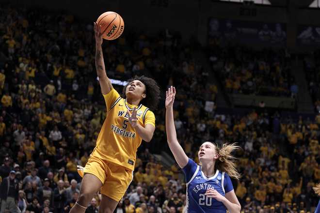West Virginia guard Sydney Shaw (5) goes up to shoot while defended by Kentucky forward Kaelyn Carroll (20) in the first half in the second round of the NCAA college basketball tournament, Monday, March 23, 2026, in Morgantown, W.Va.