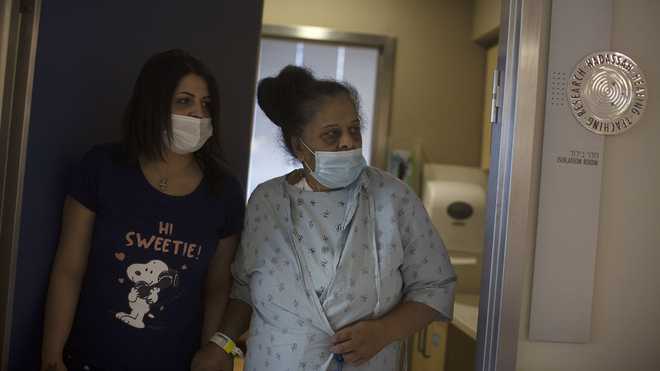 Randa Aweis, right, who received a kidney transplant from Yigal Yehoshua, a Jewish man who died May 17 after being pelted with rocks amid clashes between Arabs and Jews in Israel’s mixed city of Lod, walks with her daughter, Nevine at Hadassah Ein Karem Hospital in Jerusalem, Monday, May 24, 2021.