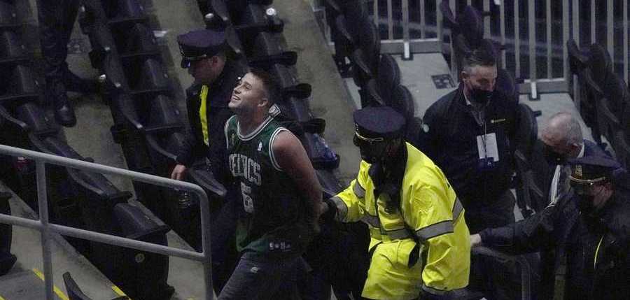 Kyrie Irving bottle incident A fan is handcuffed and escorted out of TD Garden by police after allegedly throwing a water bottle at Brooklyn Nets' Kyrie Irving as he left the court after Game 4 during an NBA basketball first-round playoff series, Sunday, May 30, 2021, in Boston. The Nets won 141-126. (AP Photo/Elise Amendola)