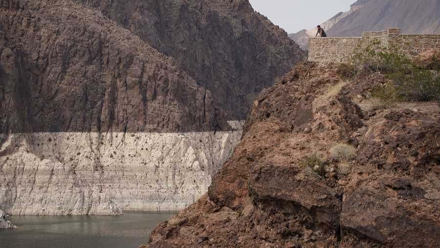 FILE - In this Aug. 13, 2021, file photo, a person looks out over Lake Mead near Hoover Dam at the Lake Mead National Recreation Area in Arizona.   A major Southern California water agency has declared a water supply alert for the first time in seven years, Tuesday, Aug. 17, 2021 and is asking residents to voluntarily conserve.  (AP Photo/John Locher, File)